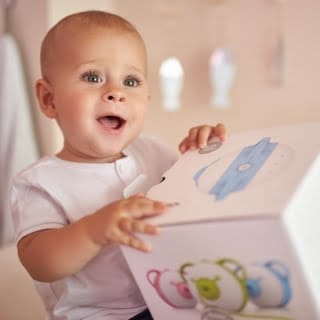 Ein faszinierter kleiner Junge hält eine Schachtel mit dem Nosiboo Pro elektrischen Baby Nasensauger in den Händen