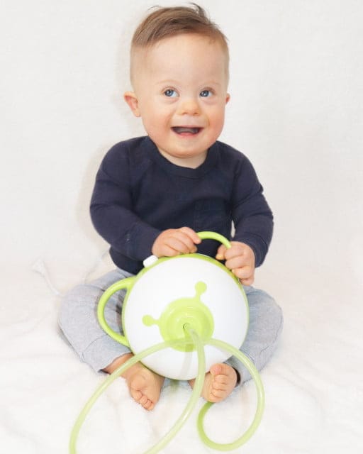 Ein kleiner lächelnder Junge hält den Nosiboo Pro elektrischen Baby Nasensauger in den Händen 